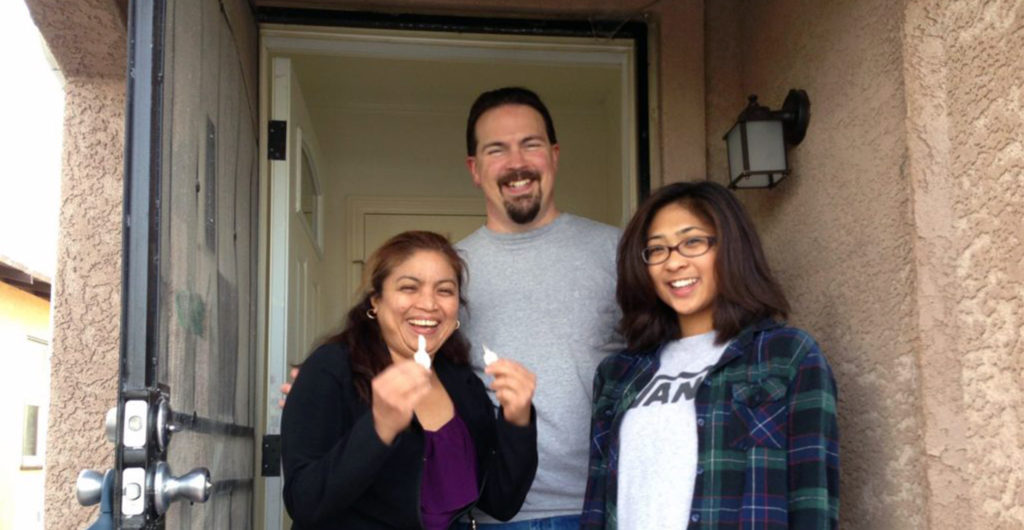 Family outside their new home secured through Oakland Community Land Trust