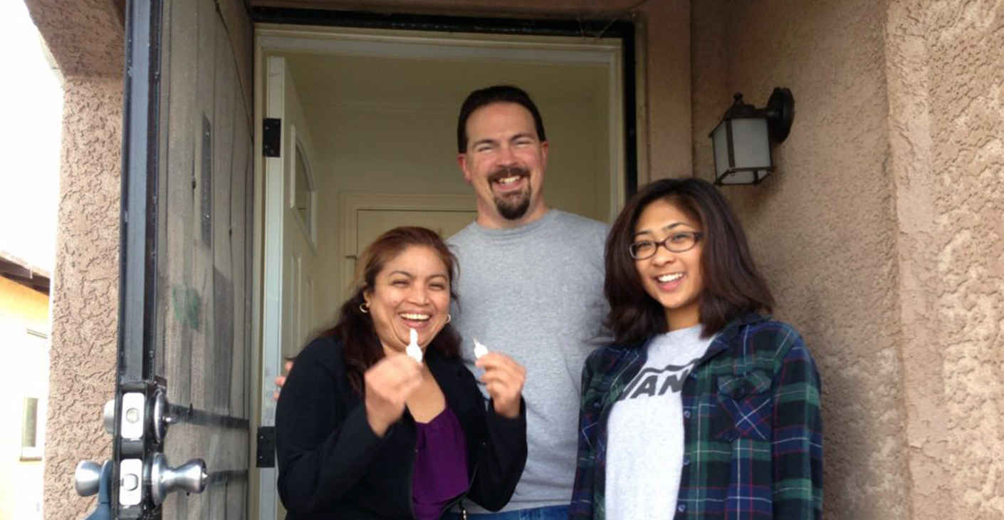 Family outside their new home secured by Oakland Community Land Trust